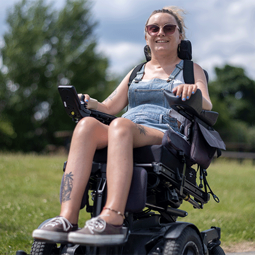 NDIS participant in a power wheelchair smiling outdoors in Seven Hills, NSW, after a continence assessment consultation.